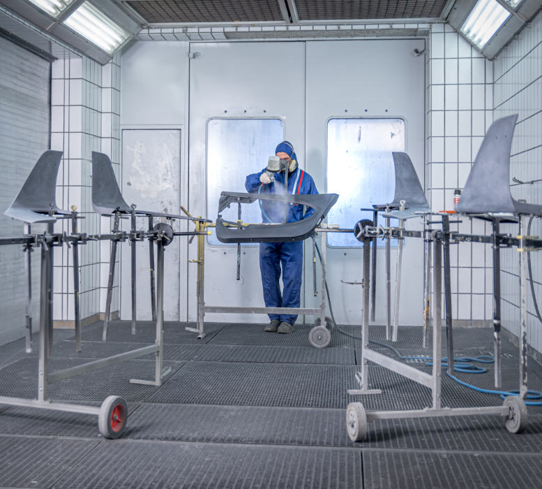 Ein Becker Carbon Mitarbeiter beim Lackieren eines Werkstückes